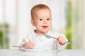 Baby practicing dining etiquette